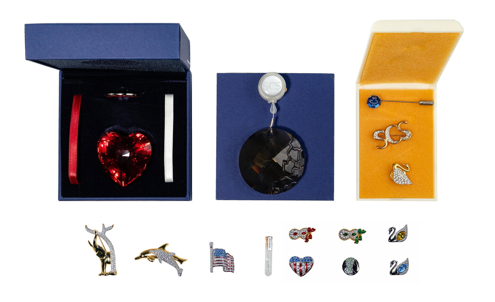 Swarovski Crystal Jewelry Assortment: Swarovski Crystal Jewelry Assortment (15) items, including 1991 SCS dolphin brooch; 2010 SCS smokey quartz suncatcher; 2004 SCS red heart ornament; all in original packaging; SCS the elephant and tree