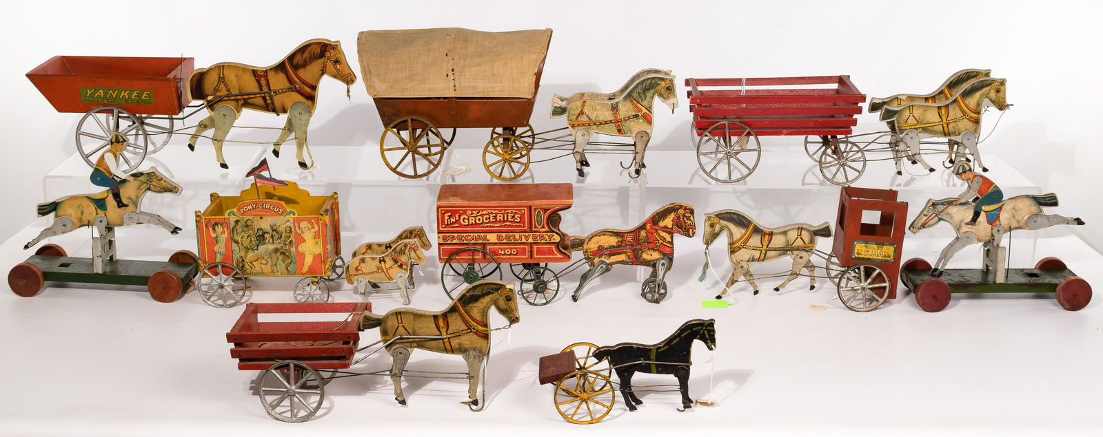 Gibbs Toy Assortment: Gibbs Toy Assortment (10) items including a Conestoga wagon, a mail carrier, a circus cart, a dump cart, race horses and jockeys, most having paper covered animated horses Height: 8 1/4 inches, Width: