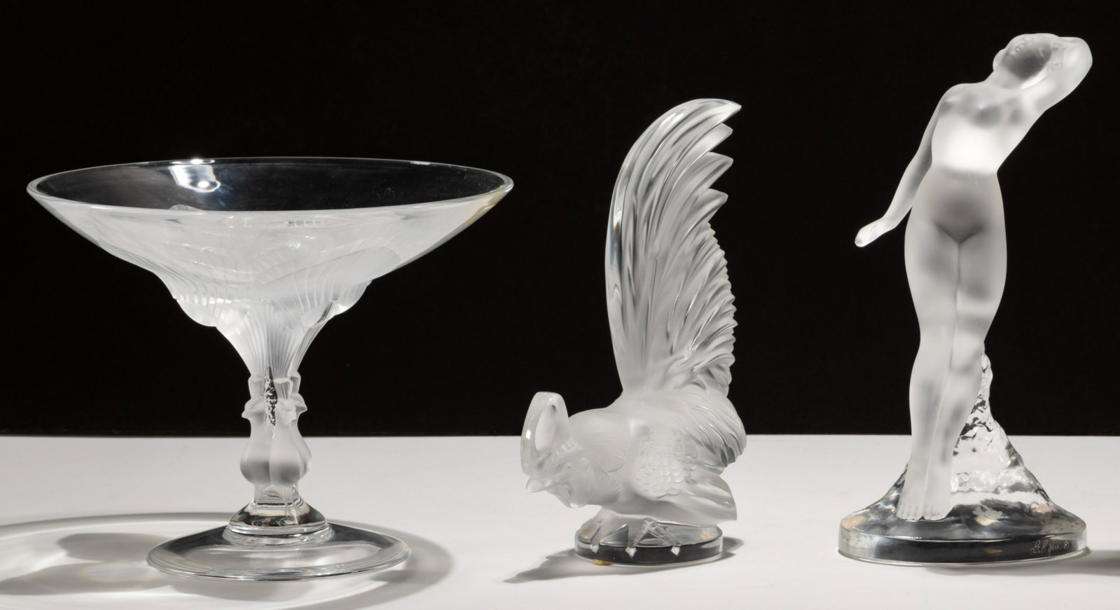 Lalique Crystal Assortment: Lalique Crystal Assortment (3) items including 'Virginia' peacock compote, 'Coq Nain' frosted rooster and 'Danseuse Bras Baisse' frosted nude figure, all having etched marks to undersides or bottom ri