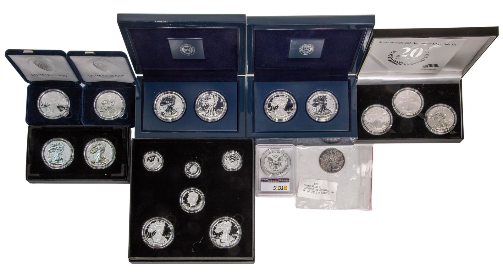 American Silver Eagle $1 Assortment: American Silver Eagle $1 Assortment (8) items including 2006 3-coin 20th anniversary set, 2013 West Point 2-coin proof sets, 2013 San Fransisco 2-coin proof sets, 2019-S enhanced reverse proof coin, 2