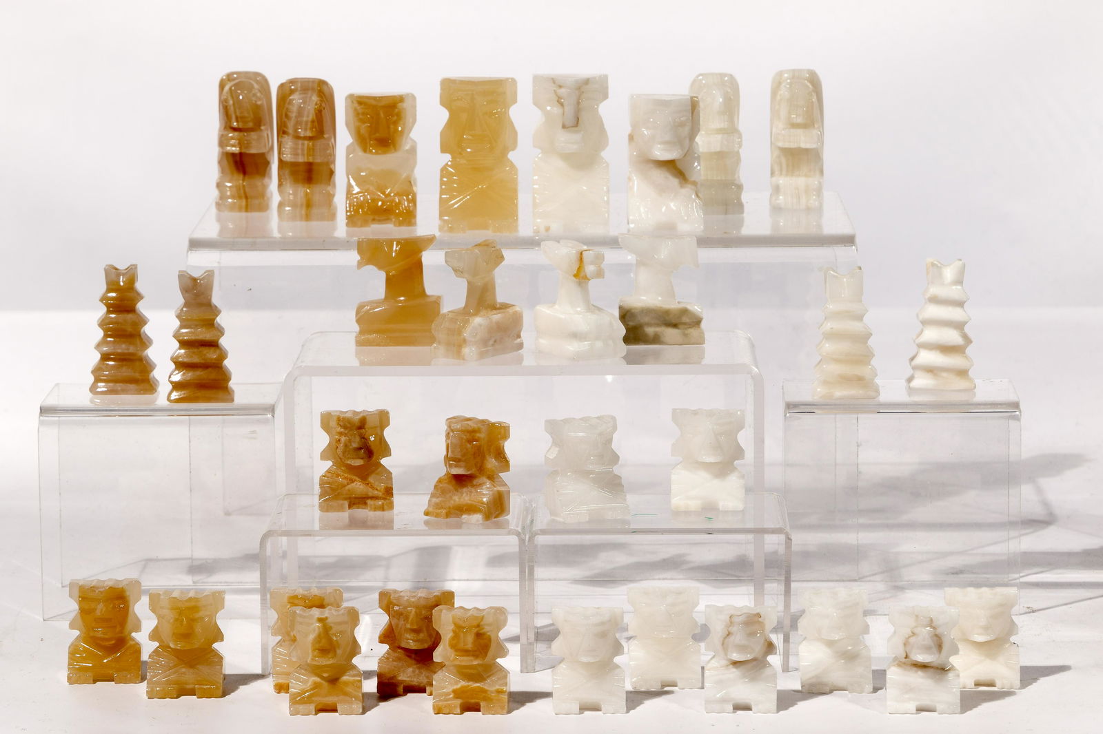 Carved Stone Chess Piece Set Assortment: Carved Stone Chess Piece Set Assortment (5) sets including Chinese jadeite jade and stone, (2) African soapstone and Mexican onyx; together with (2) soapstone chessboards having walnut frames Property