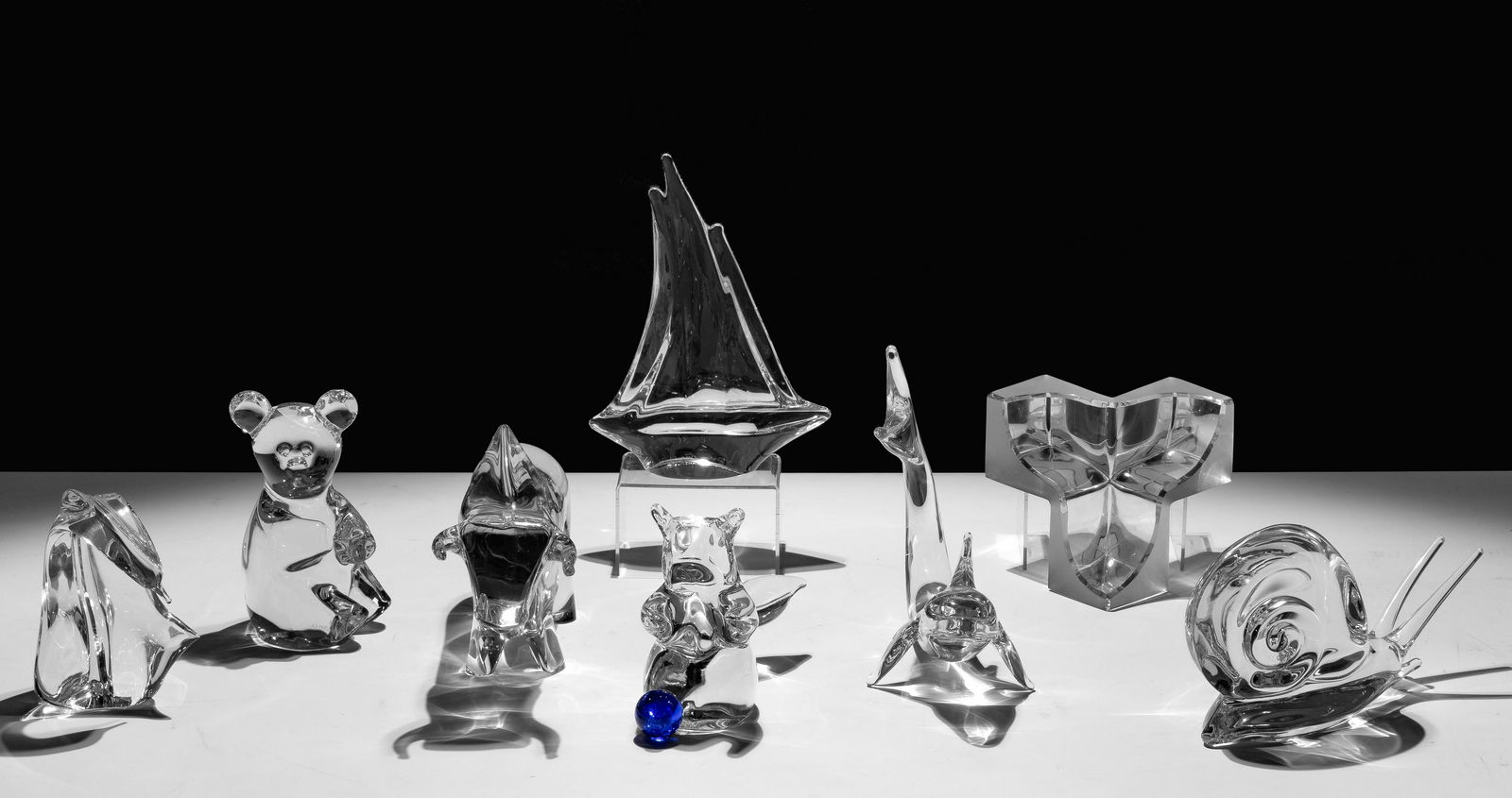 Daum Crystal Assortment: Daum Crystal Assortment (8) items including a clear and frosted vide poche bowl having (3) cubic lobes; a sailboat; a bull; a dolphin; a teddy bear; a squirrel; a snail; and a bird; all having maker e