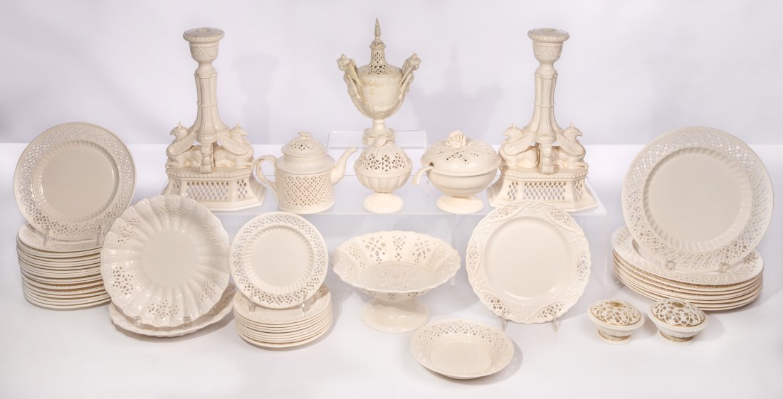 British Pierced Creamware Assortment: British Pierced Creamware Assortment (48) pieces of reticulated pottery in various patterns, unmarked including a pair of griffon motif candlesticks, a covered urn having angel handles, a footed turee
