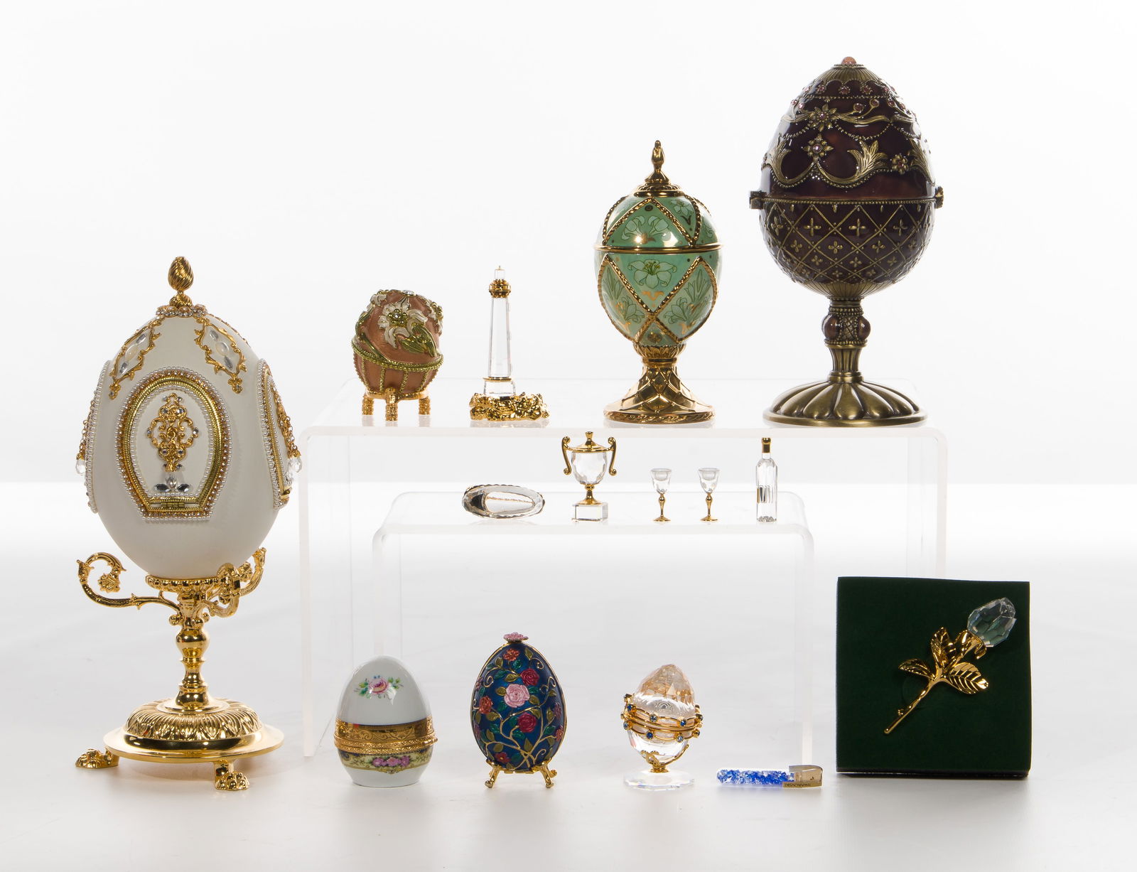 Decorative Egg and Object Assortment: Decorative Egg and Object Assortment (11) items including a House of Faberge 'Dance of the Reed Pipes Madonna Lily', (2) Rucinni painted enamel, a Limoges hinged lid porcelain desk clock, a painted en