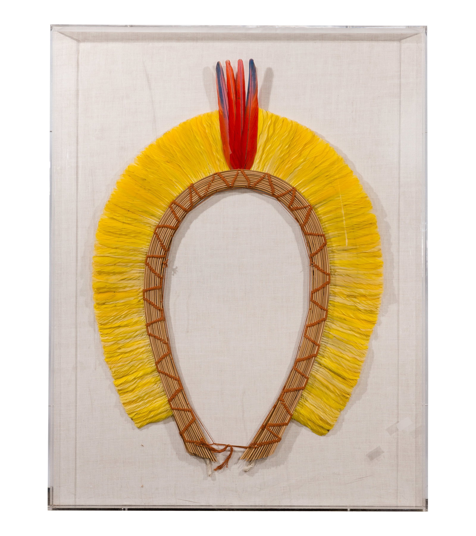 Kayapo Headdress: Kayapo Headdress A parrot feather headdress from the Xingu River area, Mato Grosso, Brazil, mounted to linen in an acrylic box frame having The Grayson Gallery, Chicago, Illinois label on back Propert