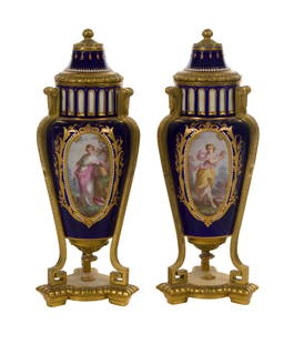 Sevres Style Garnitures: Sevres Style Garnitures A pair of cobalt and gilt lidded urns having hand-painted medallions on three sides set into a Greek style gilt metal stand, interior lined in brass, no markings Property from: