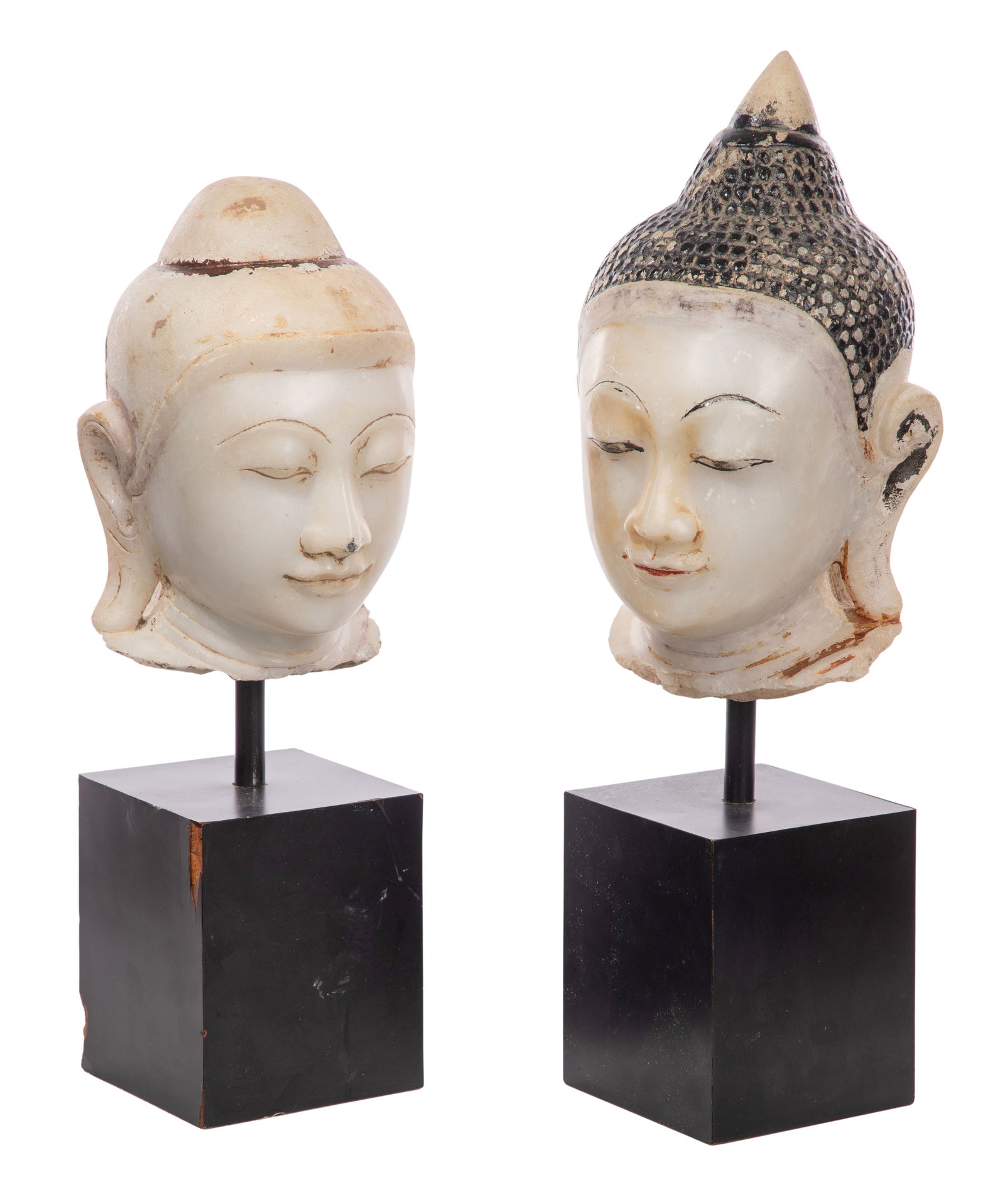 Asian Alabaster Buddha Heads: Asian Alabaster Buddha Heads (2) similar heads, hand carved from alabaster, larger having black hair and areas of paint and gilt, both on wood stands Property from: an Estate, St. Charles, Illinois He