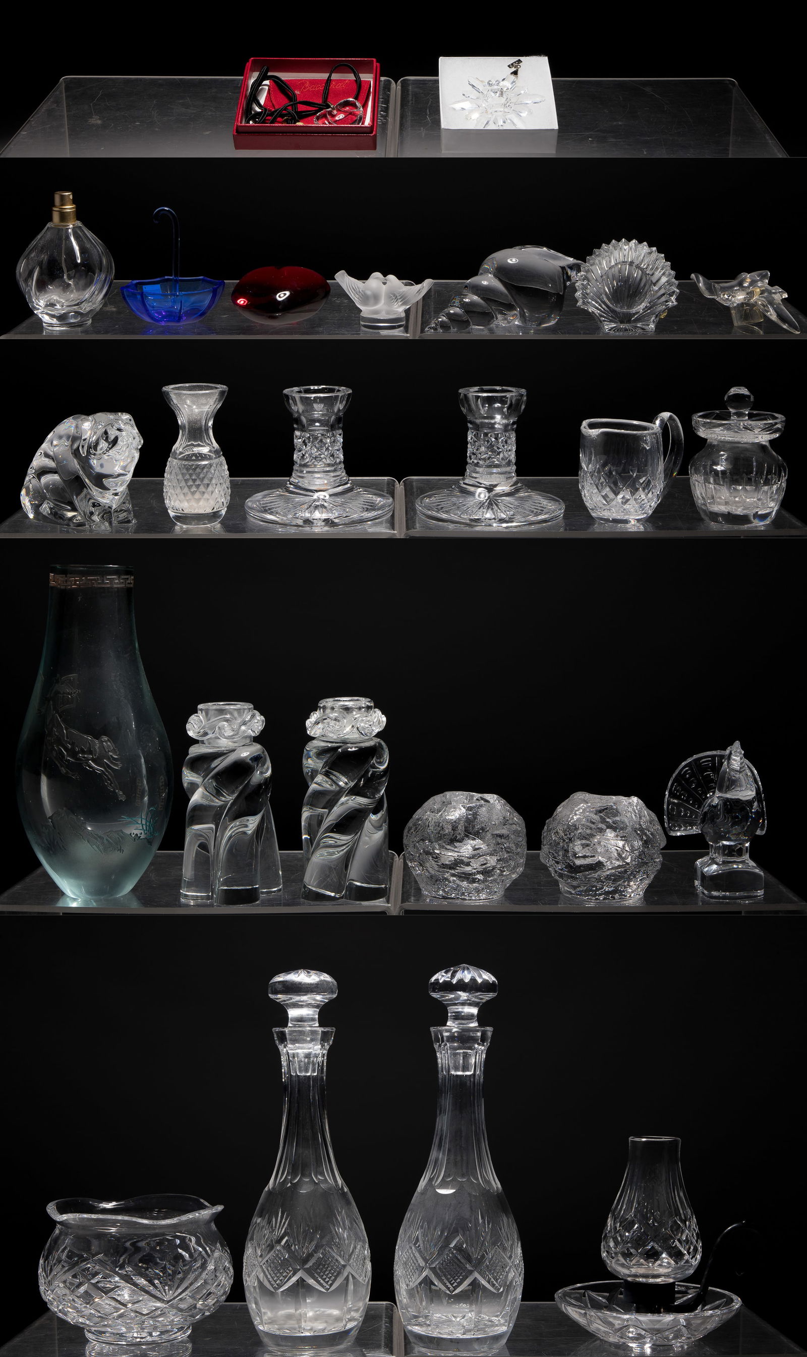 Crystal Object Assortment: Crystal Object Assortment (24) items including a Kosta Boda votive set, a Baccarat red heart paperweight, a St. Louis seashell paperweight, a Baccarat candle holder set, an empty Nina Ricci perfume bo