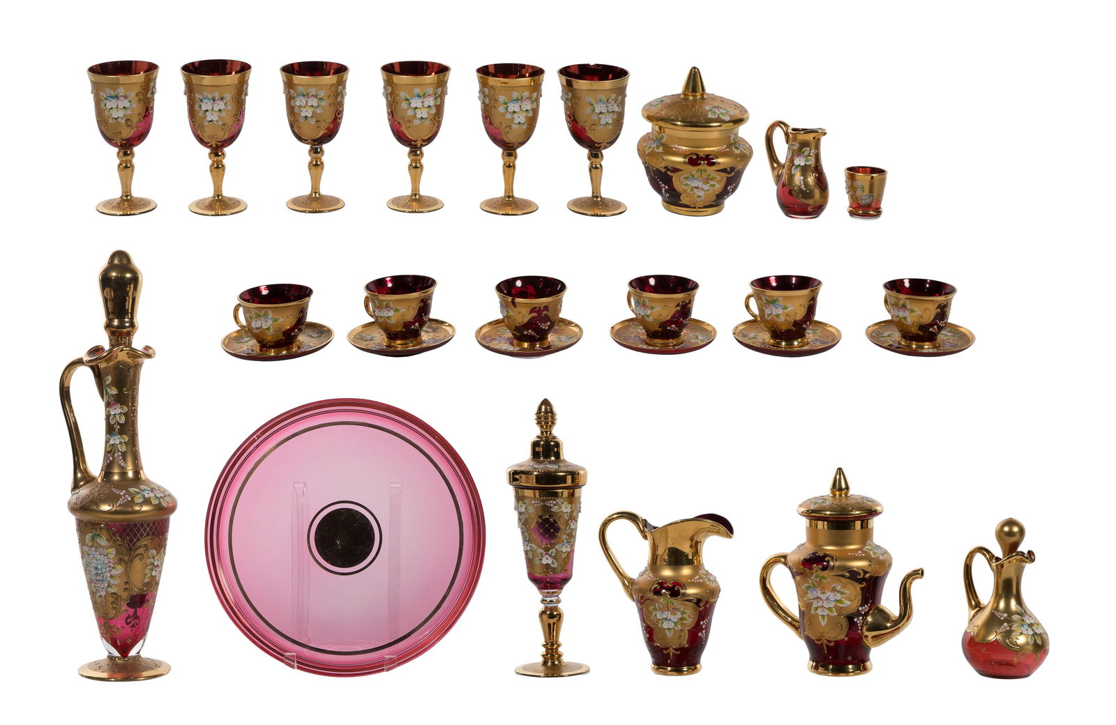 Gilt Cranberry Glass Assortment: Gilt Cranberry Glass Assortment (21) items including a set of (6) cups and saucers, (6) wine glasses, a decanter, (2) pitchers, an oil pitcher, a bowl, (2) lidded urn, a shot glass and a chocolate