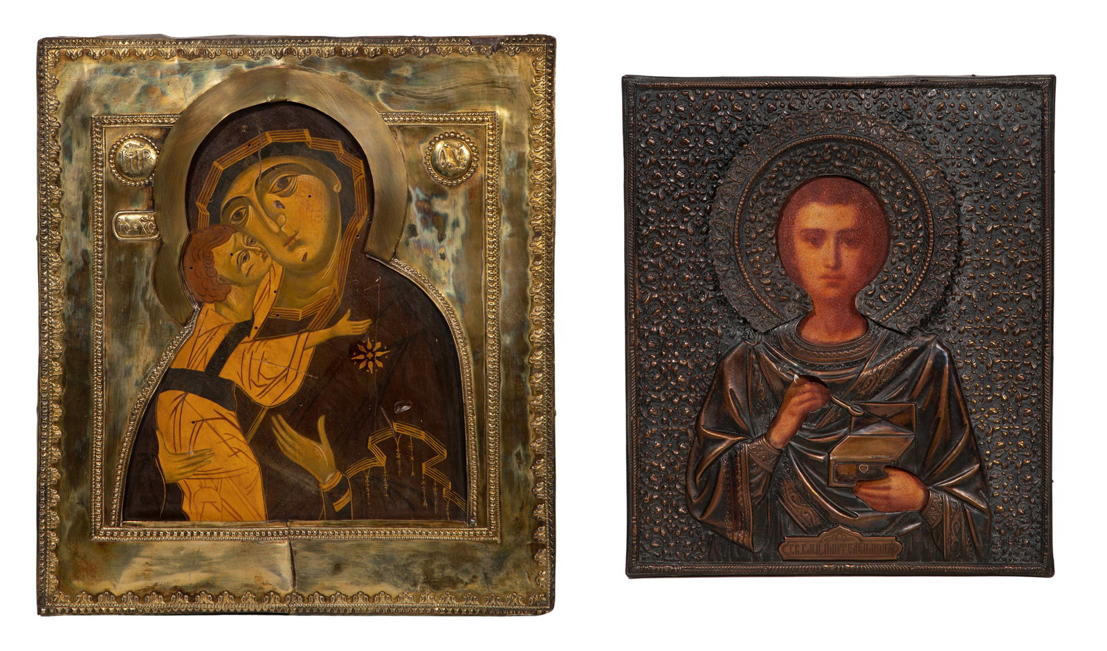 Russian Religious Icons: Russian Religious Icons (2) items including a Holy Great Martyr Panteleimon having an embossed copper-tone oklad and a depiction of Mary with the Christ Child having a brass oklad Property