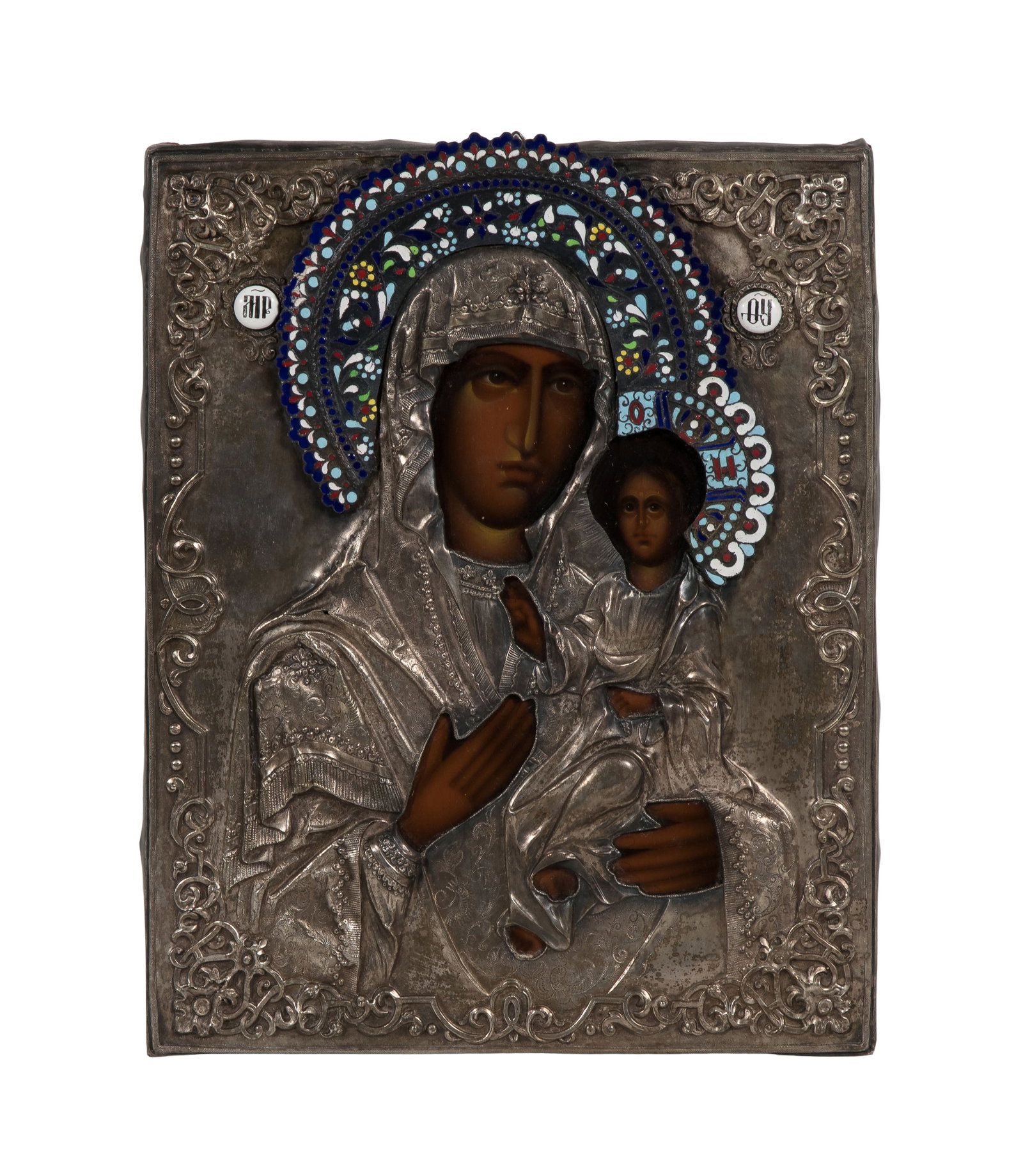 Russian Silver and Enamel Icon: Russian Silver and Enamel Icon A hand painted wood panel icon of the Mother of God behind a repousse and engraved silver oklad having attached pierced repousse halo and enamel decoration,
