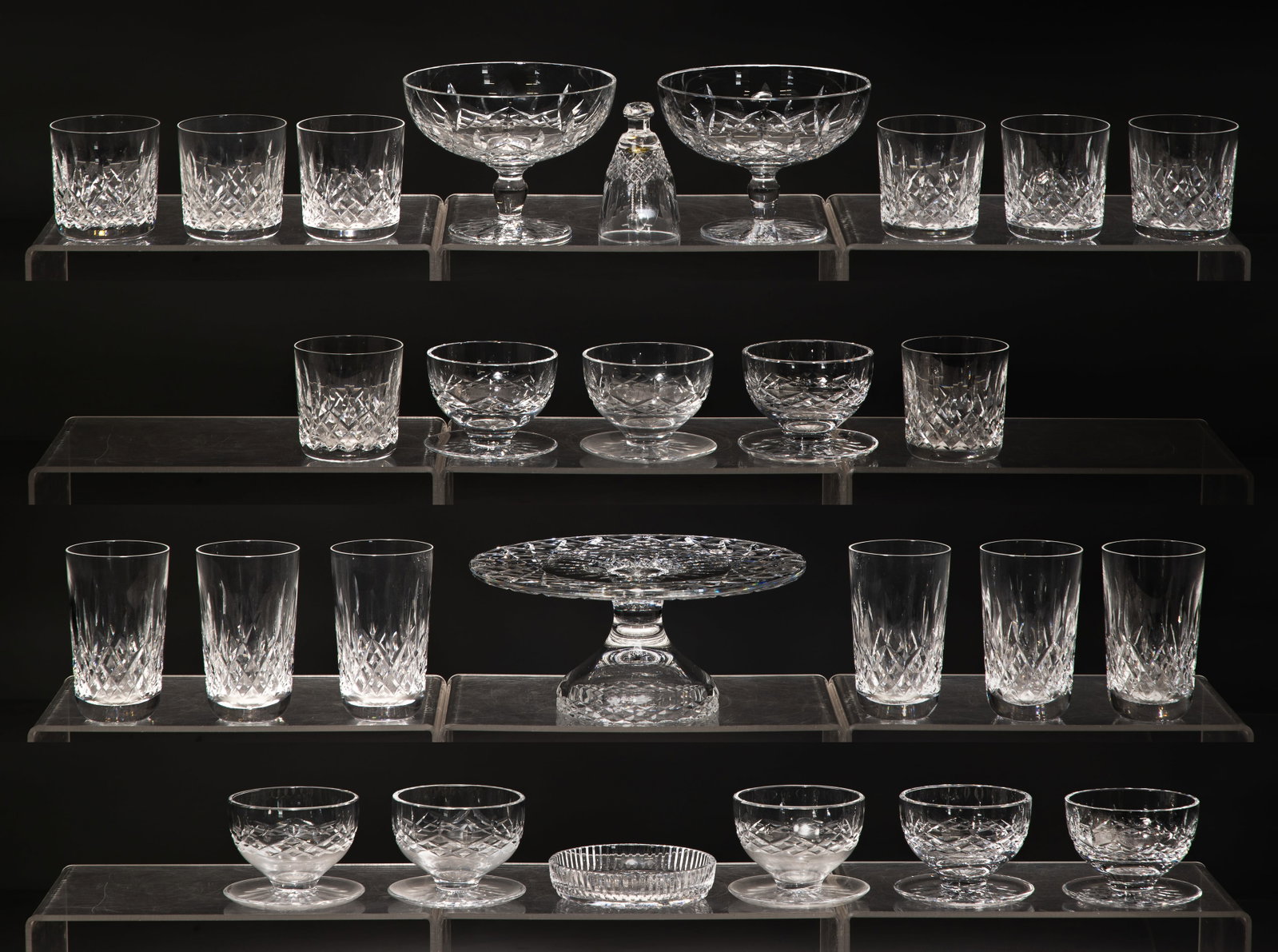 Waterford Crystal Lismore Assortment: Waterford Crystal Lismore Assortment (27) items including a set of (8) footed dessert bowls, set of (8) old fashioned glasses, set of (6) tumblers, (2) footed compotes, a cake plate, a bell and a wine