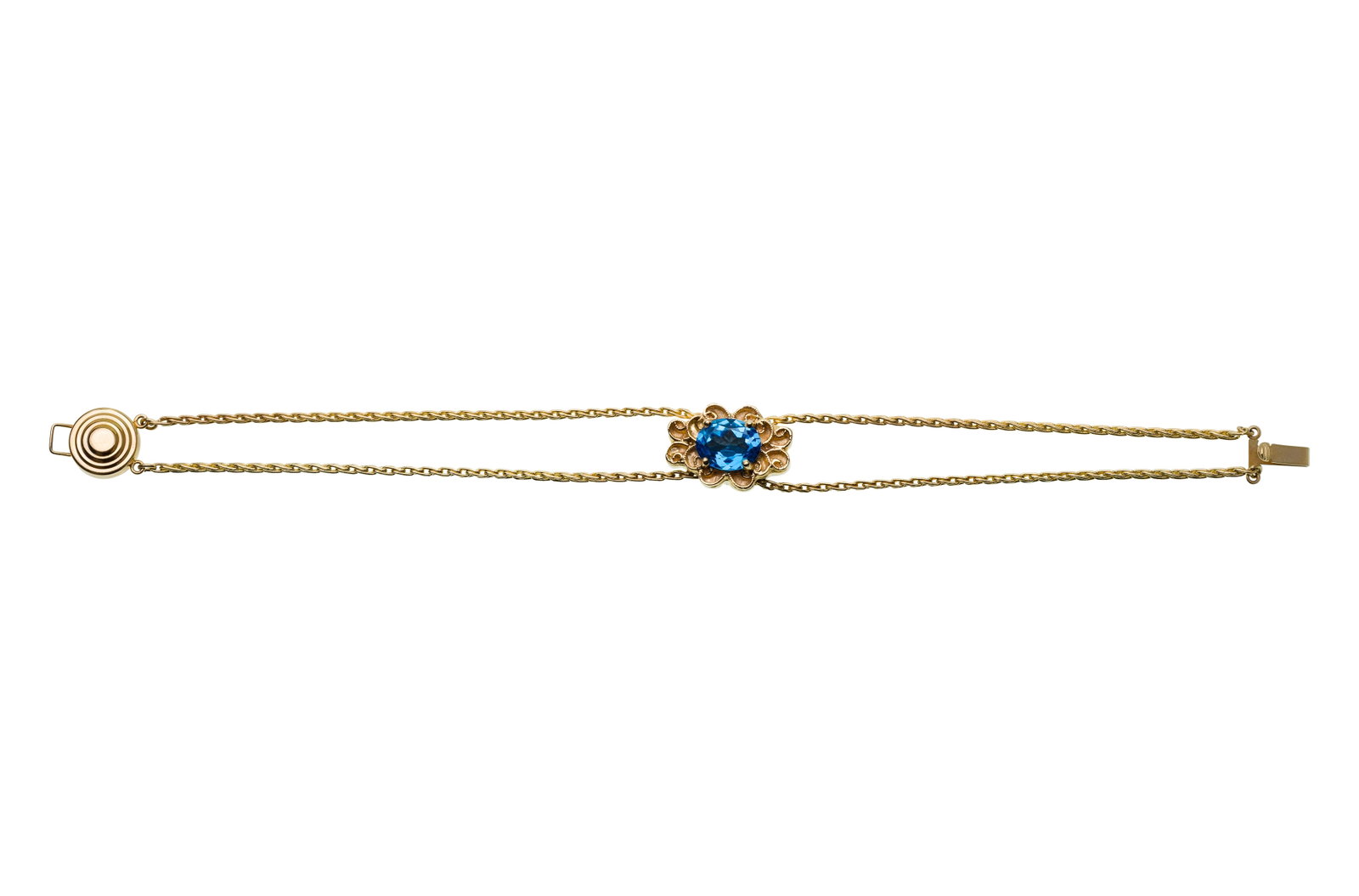 14k Yellow Gold and Blue Topaz Bracelet: 14k Yellow Gold and Blue Topaz Bracelet Having an oval cut topaz in a floriform setting, sliding on a double chain (marked '14k') Property from: a Private Collector, Westmont, Illinois Length: 7