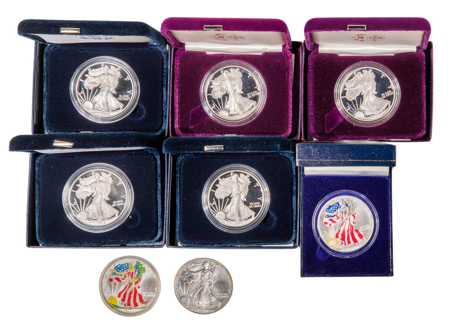 US $1 American Eagle Assortment: US $1 American Eagle Assortment (8) coins including (2) from 1986 and (3) from 2010, all having the paperwork and boxes as well as a 1999, a colorized from 1999 having the paperwork and box and a