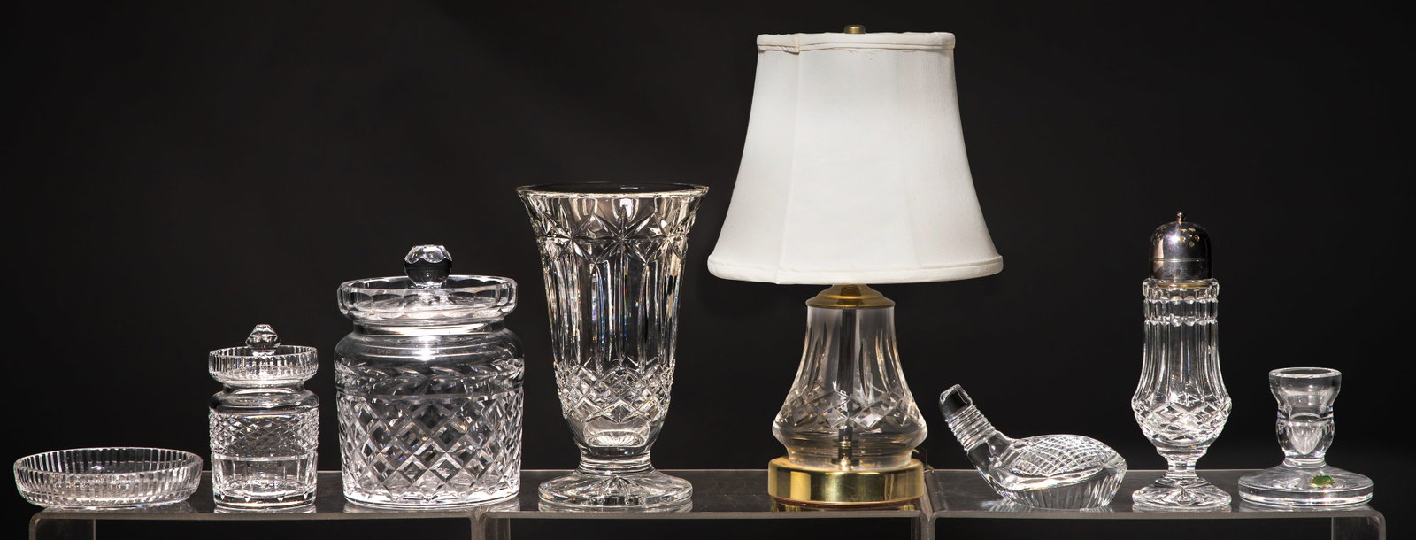 Waterford Decorative Object Assortment: Waterford Decorative Object Assortment (8) items including a lamp having diamond-cut glass base, pleated white fabric shade and brass-tone hardware, a flared footed vase, a biscuit jar, a honey pot,