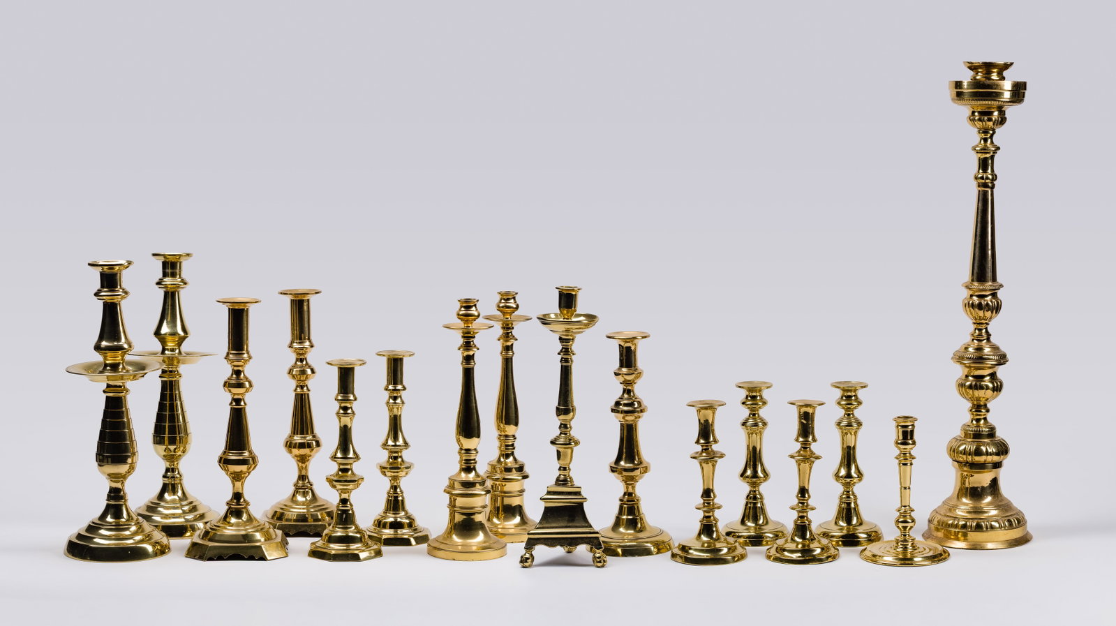 Brass Candlestick Assortment: Brass Candlestick Assortment (16) items including (4) matching pairs and (8) singles Property from: a Private Collector, Wheaton, Illinois Height: 27 1/2 inches, Diameter: 8 1/2 inches (tallest)