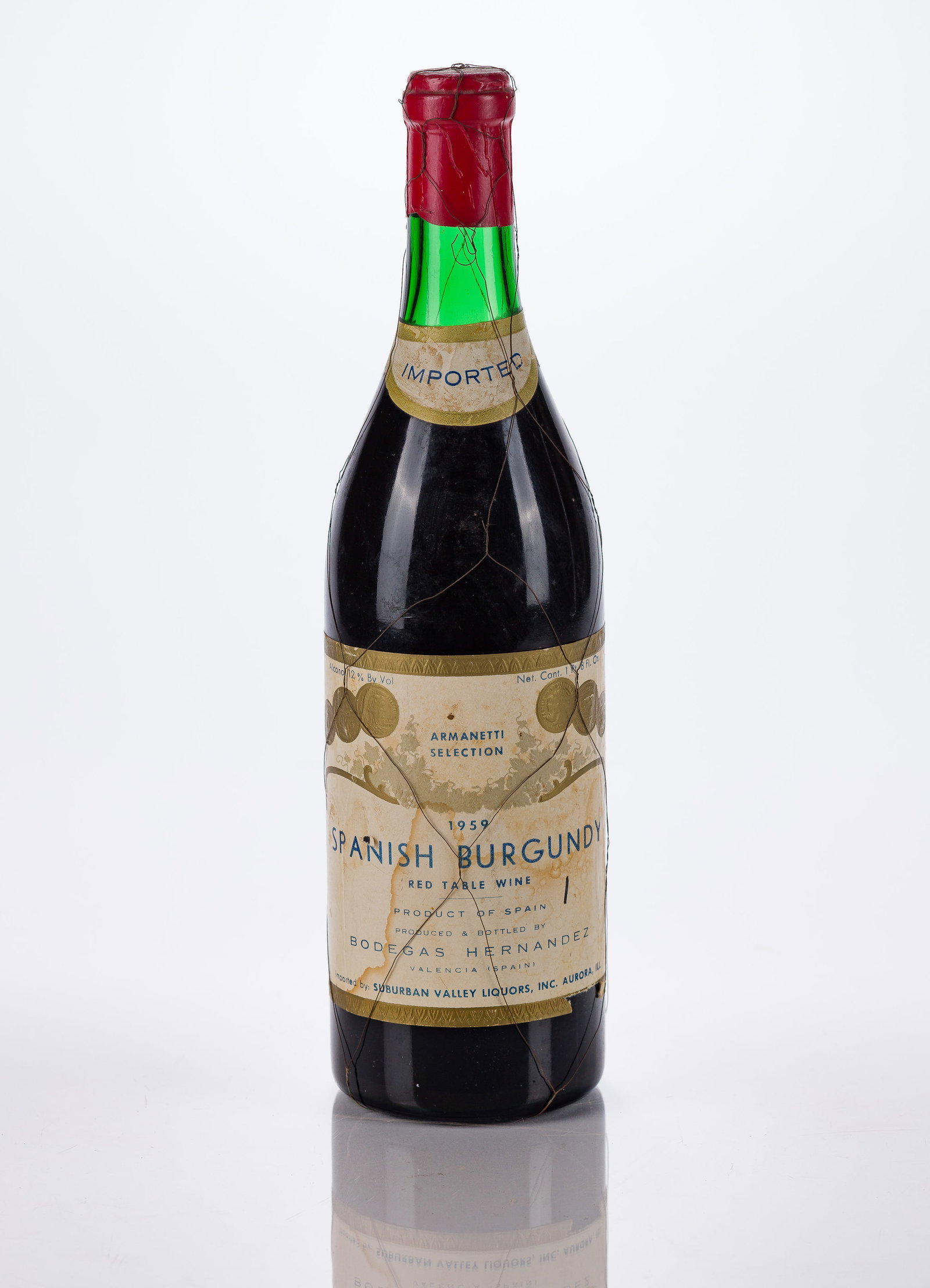 1959 Spanish Burgundy: 1959 Spanish Burgundy Bottled by Bodegas Hernandez, imported by Armanetti Liquors in a thin wire net, fill: 3.5 cm or better, labels: fully legible, intact, bin soiling, minor tearing at edges from me