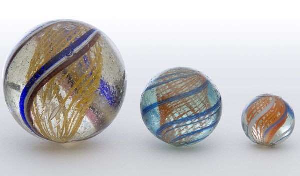 Latticino Swirl Marbles: Latticino Swirl Marbles Three marbles having a orange interior swirl Diameter: 2.05 inches (largest) Category: Collectibles > Marbles Shipping Status: Leonard Auction, Inc. will directly ship via USPS