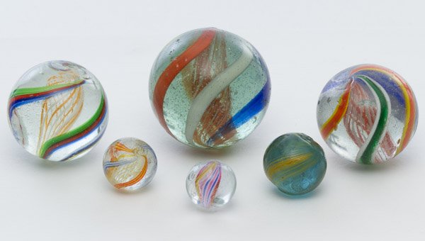 Latticino Swirl Marbles: Latticino Swirl Marbles Six marbles; three marbles have a interior orange and white swirl with exterior multi-colored swirl and three marbles have a multi-color interior swirl and a multi-colored exte