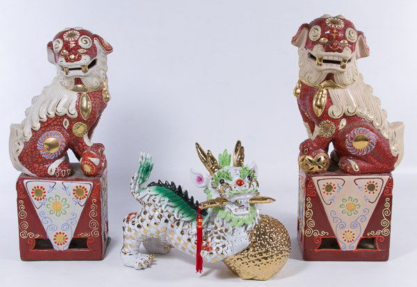 Ceramic Foo Dogs and Dragon: Ceramic Foo Dogs and Dragon Including a pair of gold and brick red enameled Foo dogs on square bases, together with a gilded dragon figurine holding a ball and with dagger in mouth Height: 16.00 inche