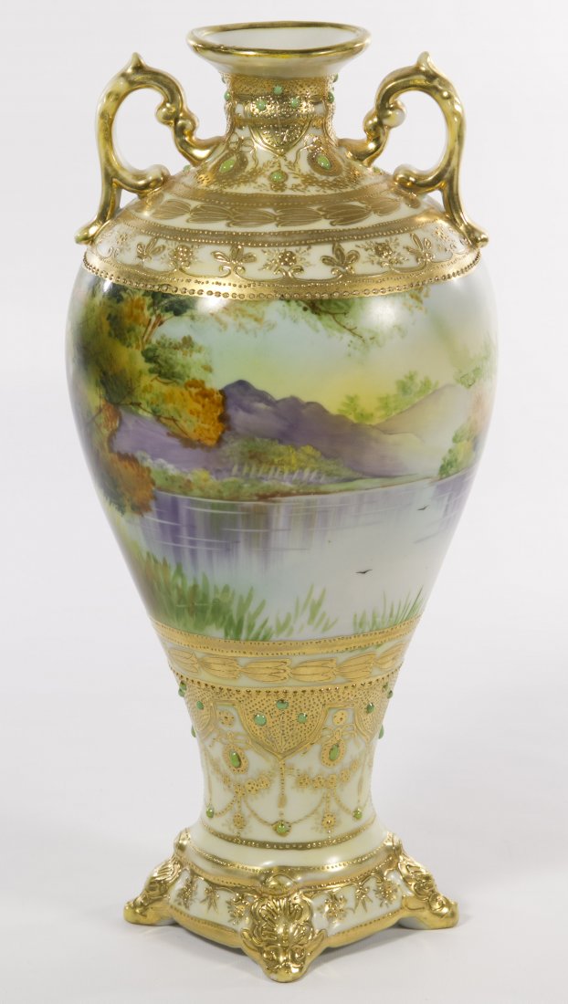 Nippon Porcelain Scenic Vase: Nippon Porcelain Scenic Vase c.1910; having two handles, lake scene, moriage and gilded decoration; the underside marked with a blue maple leaf Height: 11.75 inches Category: Porcelain and Ceramics > 