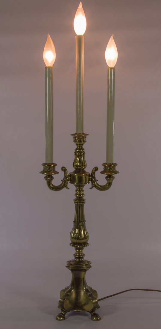 Tri-Candle Brass Lamp by Loevsky & Loevsky: Tri-Candle Brass Lamp by Loevsky & Loevsky Having a four footed brass base, classical style post and plastic covered candle poles Height: 32.00 inches Category: Marketplace > Decorative Arts Shipping