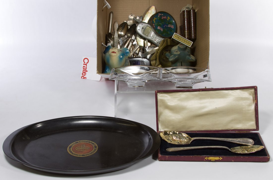Silverplate Flatware and Decorative Arts Assortment: Silverplate Flatware and Decorative Arts Assortment Including silver plate utensils, one sterling silver handled cake knife, two ceramic piggy banks, two Nambre crystal dishes, Saddam Hussein playing 