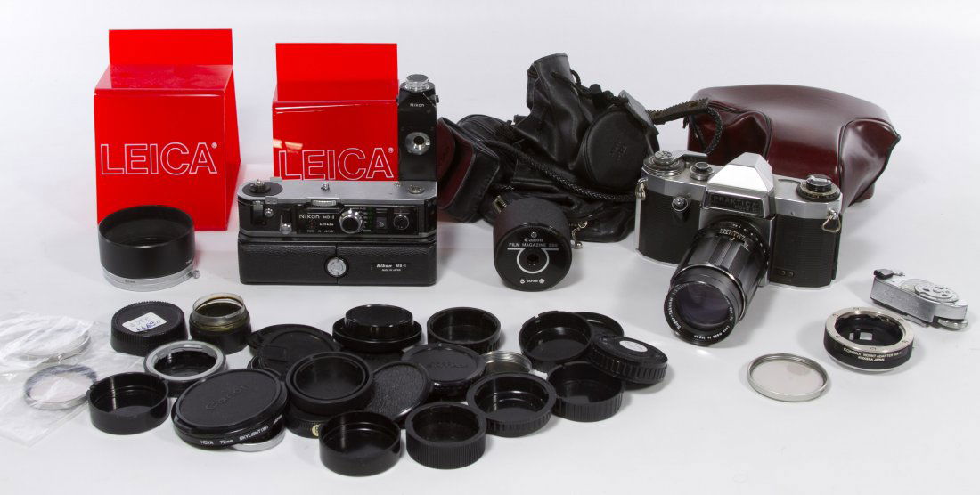 35mm Camera Assortment: 35mm Camera Assortment Including a Praktica Nova B camera with an Asahi Pot Co. lense, a Nikon MD-2 flash attachment, two red plastic Leica stands, lense caps and camera bags Width: 6.00 inches (camer