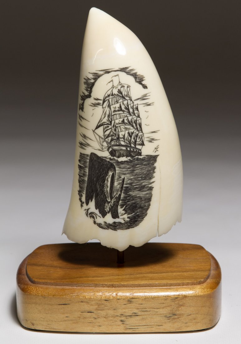 Scrimshaw Style Carved Tooth: Scrimshaw Style Carved Tooth 20th Century, having a etched design of a whale and sailboat in the water; includes the wood stand Height: 4.00 inches Category: Decorative Arts > Objects Shipping Status: