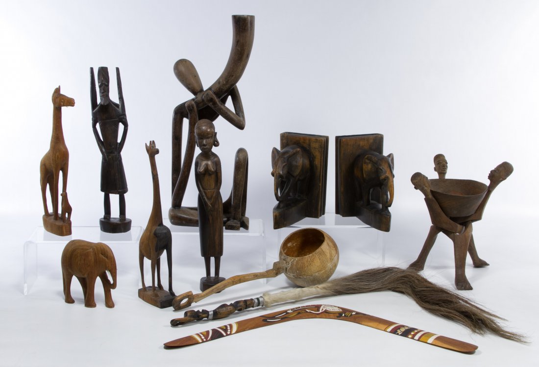 African Wooden Tribal Art Assortment: African Wooden Tribal Art Assortment Twelve items including a figural tripod stand with bowl, a boomerang, carved animal and figural statues, a dipper, elephant bookends and a Gnu tail whip; ** can on