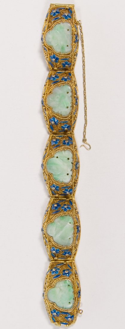 Gold Vermeil Sterling Silver and Jadeite Bracelet: Gold Vermeil Sterling Silver and Jadeite Bracelet Bracelet having Buddha carved jadeite and enameled flowers in five raised sections; safety chain Length: 6.75 inches Weight: 29.19 dwts. (total weight