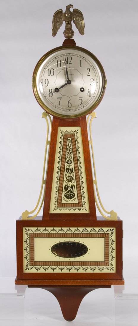 Seth Thomas 8-Day A 200 Series Wall Clock: Seth Thomas 8-Day A 200 Series Wall Clock Having a metal eagle finial, banjo shape body with painted glass door at bottom and model 'E899-159' en verso on the paper label Height: 30.00 inches Category