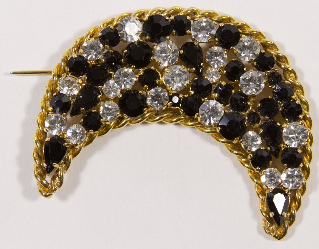 Isabel Canovas Pin: Isabel Canovas Pin Having a crescent moon shape with clear and black glass faceted stones Height: 2.75 inches Category: Jewelry and Timepieces > Costume Shipping Status: Leonard Auction, Inc. will dir
