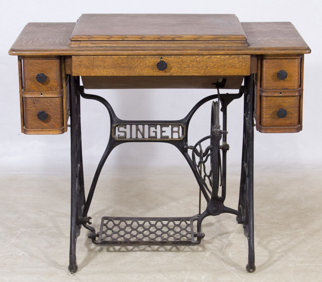 Oak Treadle Sewing Machine by Singer: Oak Treadle Sewing Machine by Singer Oak cabinet on cast iron treadle base with center drawer flanked by two drawers on each side Height: 31.00 inches, Width: 36.00 inches, Depth: 18.00 inches Categor