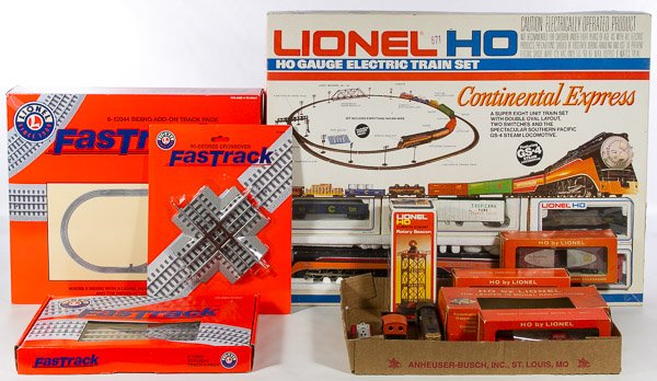 Lionel Model Train and Track Assortment: Lionel Model Train and Track Assortment Including three boxes/packages of 'Fastrack,' a 'Continental Express' complete train set and assorted HO hard plastic train cars Width: 26.00 inches Category: T