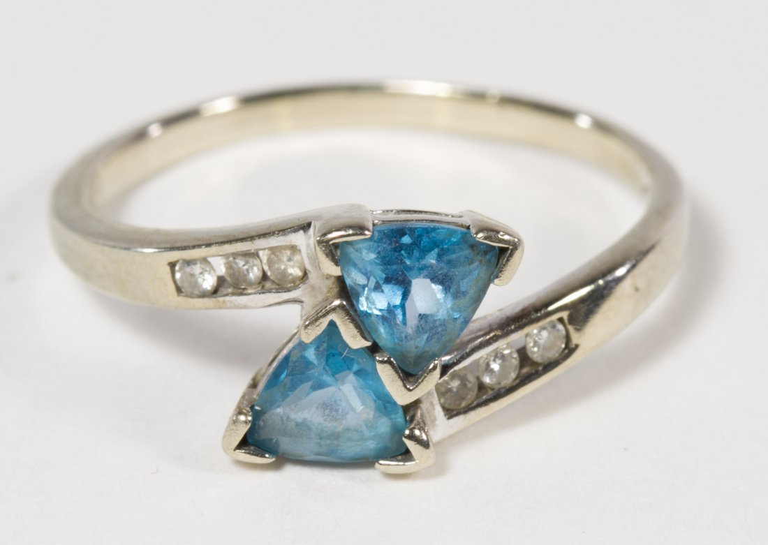 10k White Gold, Blue Topaz and Diamond Ring: 10k White Gold, Blue Topaz and Diamond Ring Having two trillion cut stones flanked by three diamond chips on each side Size: 9 Weight: 1.74 dwts. (total weight) Category: Jewelry and Timepieces > 10k