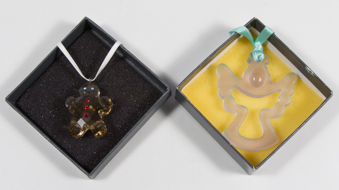 Daum and Swarovski Ornaments: Daum and Swarovski Ornaments Two ornaments including a Swarovski gingerbread man and a Daum light blue angel Height: 2.50 inches (angel) Category: Crystal > Daum Shipping Status: Due to size, weight, 