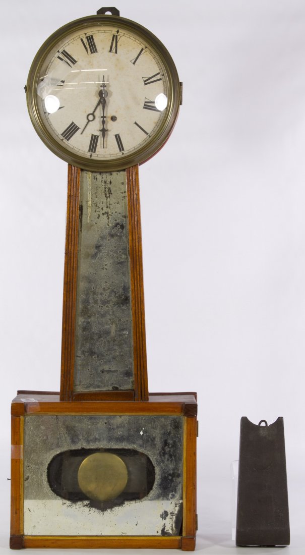 Mahogany Banjo Wall Clock: Mahogany Banjo Wall Clock Having a brass clock mechanism, paper over metal dial, mahogany case, a weight, a pendulum and mirror painted glass doors Height: 29.00 inches (clock) Category: Decorative Ar