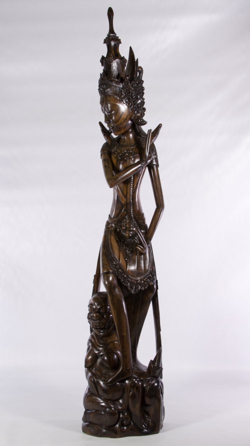 Ida Bagus Tilem (Indonesian / Balinese, 1936-1993) Wood: Ida Bagus Tilem (Indonesian / Balinese, 1936-1993) Wood Carving Dark stained solid exotic wood carving of an Indonesian female goddess figure with her foot on a masked female form at the base; purchas
