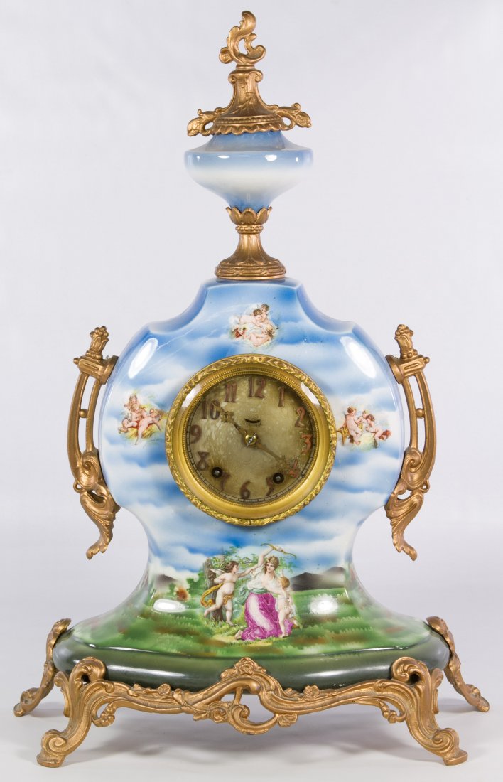 Porcelain Mantel Clock by Seth Thomas: Porcelain Mantel Clock by Seth Thomas Having a Seth Thomas D 105 clockworks mechanism, transfer print images of cherubs on the porcelain body, gold painted metal Rococo style mounts and a brass dial w