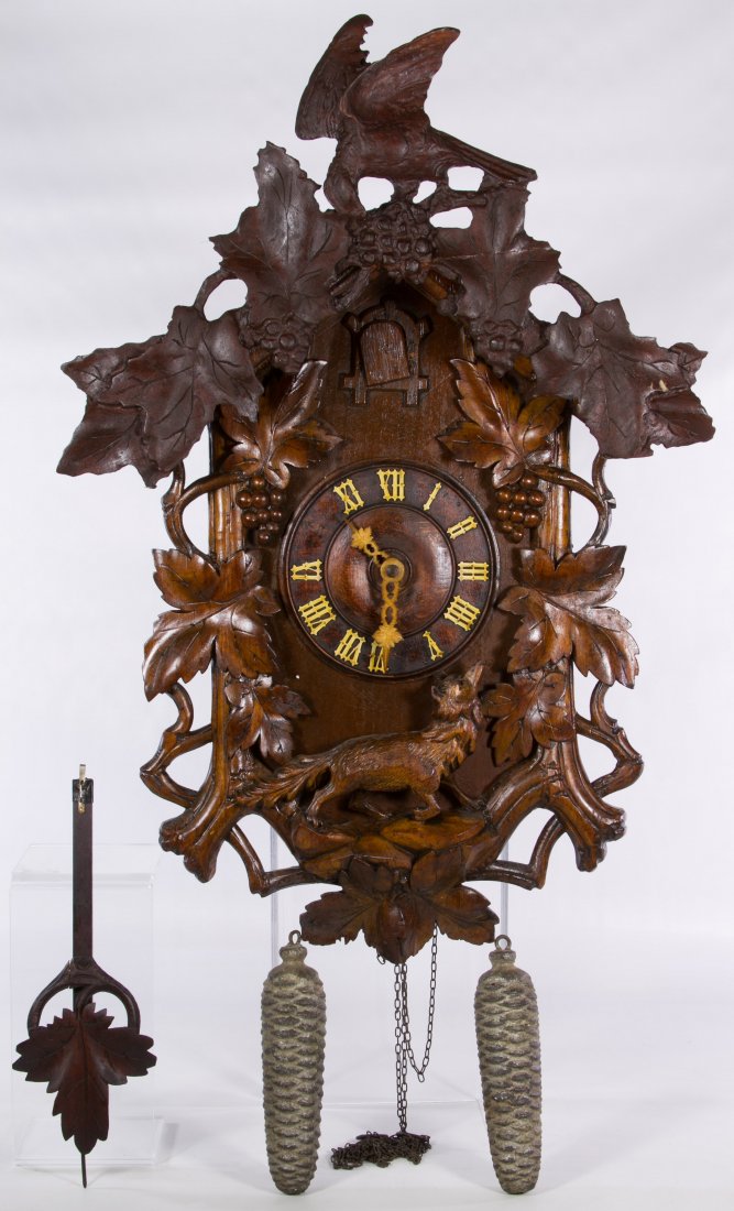 Black Forest Cuckoo Clock: Black Forest Cuckoo Clock Having a bird with grape leaf crest and a carved fox below the wood face; including two weights and a pendulum Height: 26.00 inches, Width: 17.00 inches Category: Decorative 