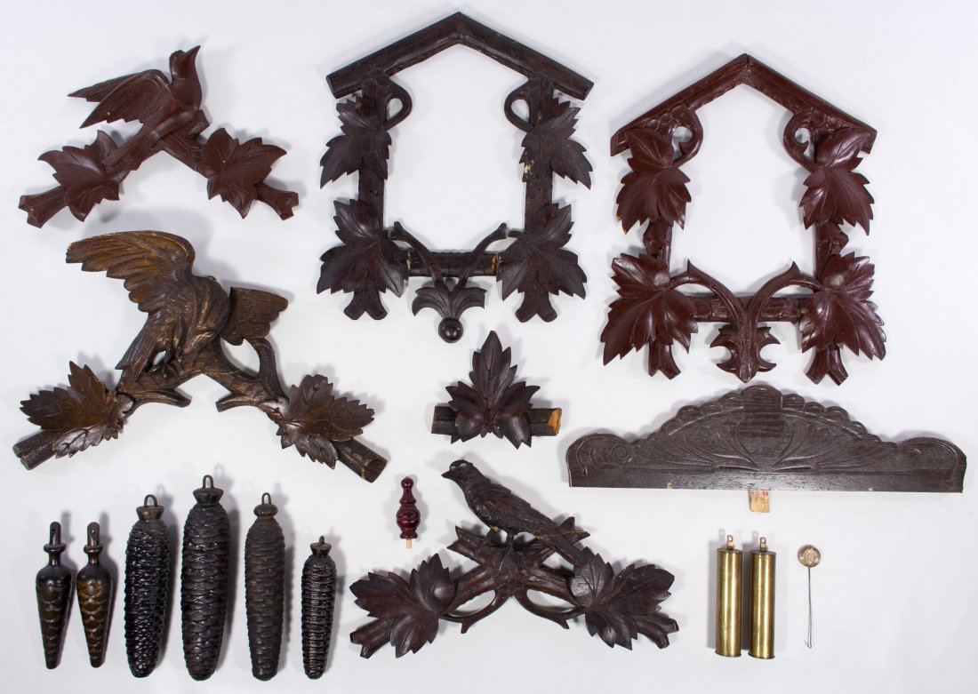 Black Forest Carved Wood Clock Parts: Black Forest Carved Wood Clock Parts Including two front frames for cuckoo clocks, three carved bird crests, weights and a German coin pendulum Height: 15.00 inches, Width: 10.00 inches (largest part)