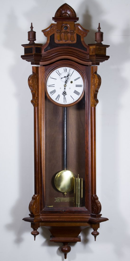 Carved Mahogany Wall Clock: Carved Mahogany Wall Clock 20th Century, having a floral motif; including pendulum, weight and crank Height: 51.00 inches, Width: 17.00 inches, Depth: 8.00 inches Category: Decorative Arts > Clocks Sh