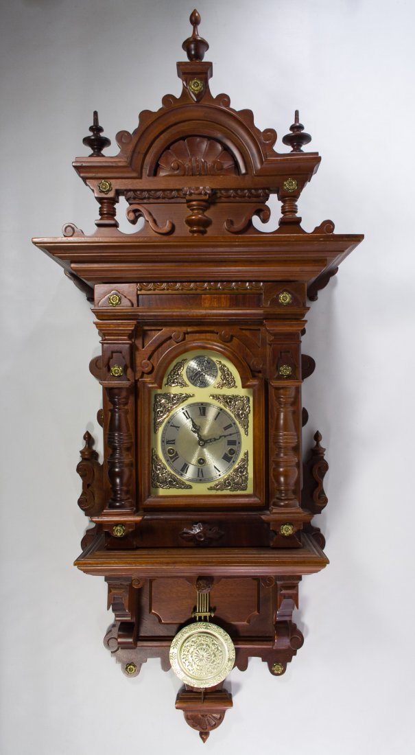 Mahogany 'Tempus Fugit' Chiming Wall Clock: Mahogany 'Tempus Fugit' Chiming Wall Clock Having a turned spindle mahogany case, a metal and plastic face and a 'made in Korea' mark en verso; including pendulum and key Height: 43.00 inches Category
