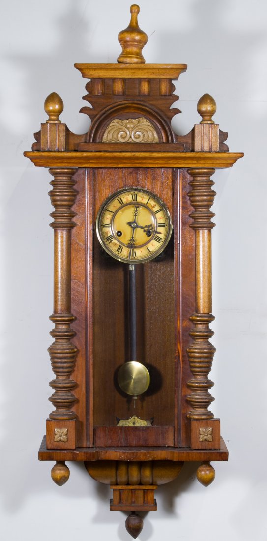 Mahogany Wall Clock: Mahogany Wall Clock Early 20th Century, having pilaster sides and a classical top; including key and pendulum; produced in Japan Height: 40.00 inches, Width: 15.50 inches, Depth: 8.00 inches Category: