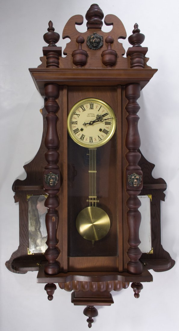 Mahogany Wall Clock by the Southern Clock Co: Mahogany Wall Clock by the Southern Clock Co 20th Century, having lion head motif and two side panel mirrors; including pendulum and key Height: 48.00 inches, Width: 28.00 inches, Depth: 8.00 inches C