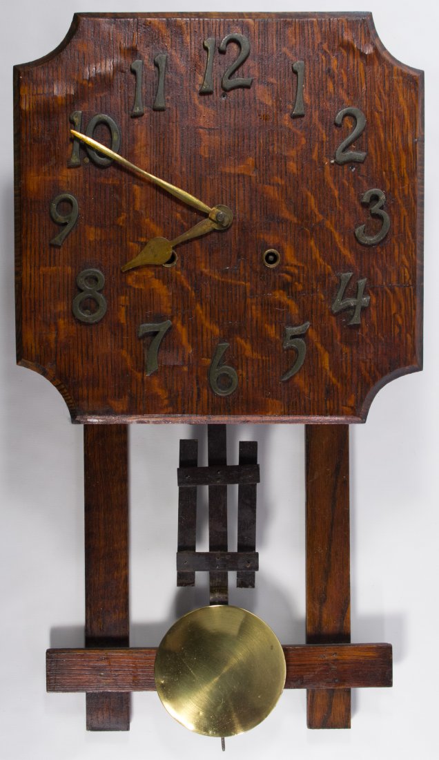 Mission Oak Wall Clock: Mission Oak Wall Clock Having an oak veneer face with brass numbers and hands, a partial manufacturer's label en verso and a brass pendulum Height: 23.00 inches Category: Decorative Arts > Clocks Ship