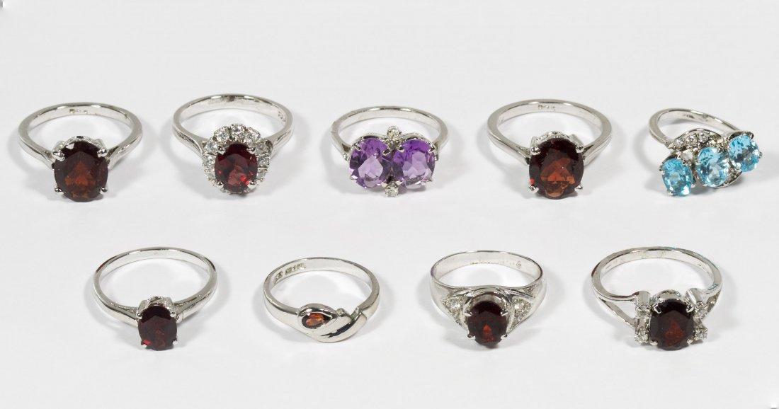 Sterling Silver and Semi-Precious Gemstone Rings: Sterling Silver and Semi-Precious Gemstone Rings Nine rings all set with gemstones including garnets, amethyst and blue topaz, some with clear crystal adornments Size: 3.5 to 7.5 Weight: 17.49 dwts. (