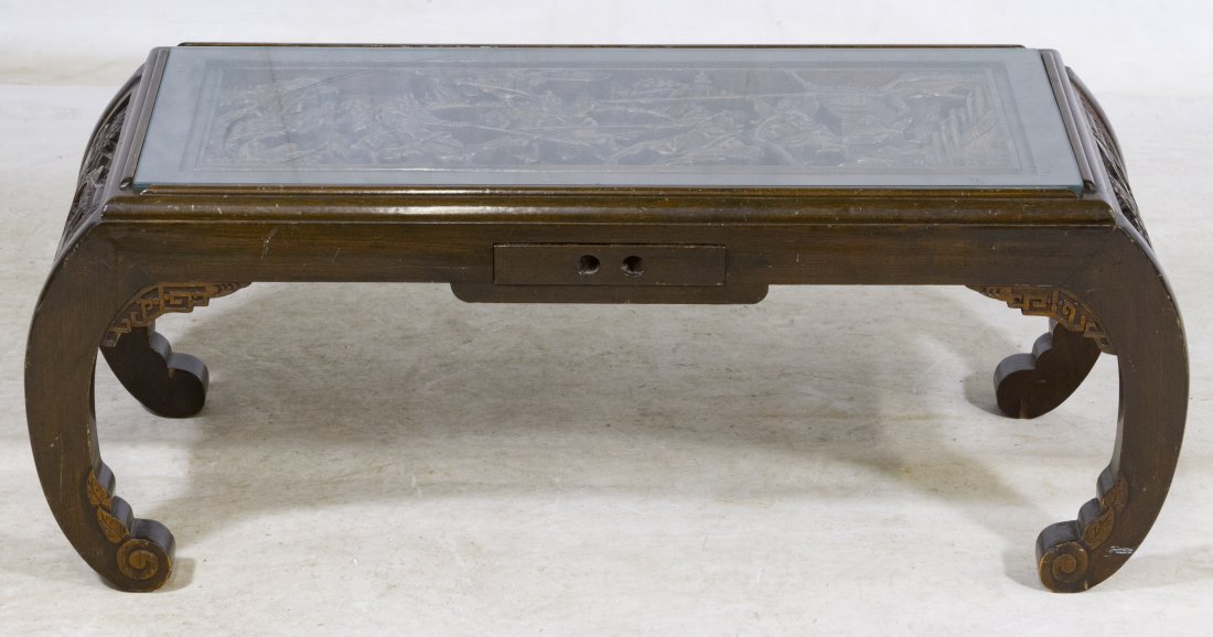 Asian Carved Teak Coffee Table: Asian Carved Teak Coffee Table Contemporary, having a carved battle scene under a glass top with a drawer Height: 15.50 inches, Width: 39.00 inches, Depth: 16.00 inches Category: Furniture > Contempor