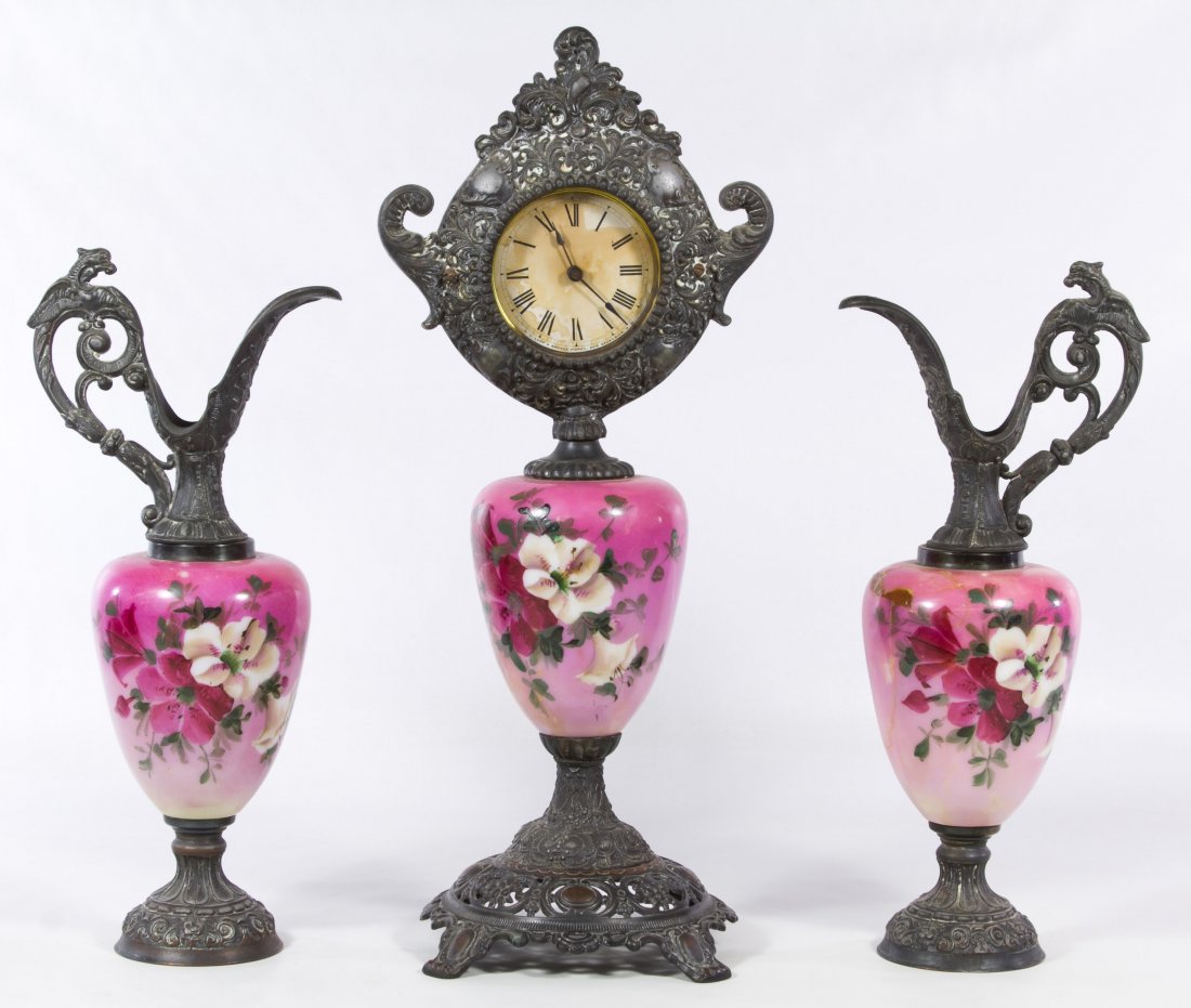 H.J. Lamp & Bronze Co. Rococo Revival Clock and: H.J. Lamp & Bronze Co. Rococo Revival Clock and Garniture Set Three matching items including a clock and two ewers with Rococo style metal mounts supporting hand painted floral glass urns topped with
